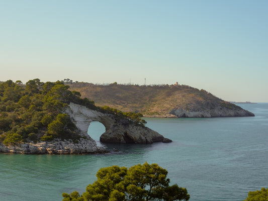 The white limestone Arco di San Felice at sunset in the Gargano Peninsula, in Puglia, Italy