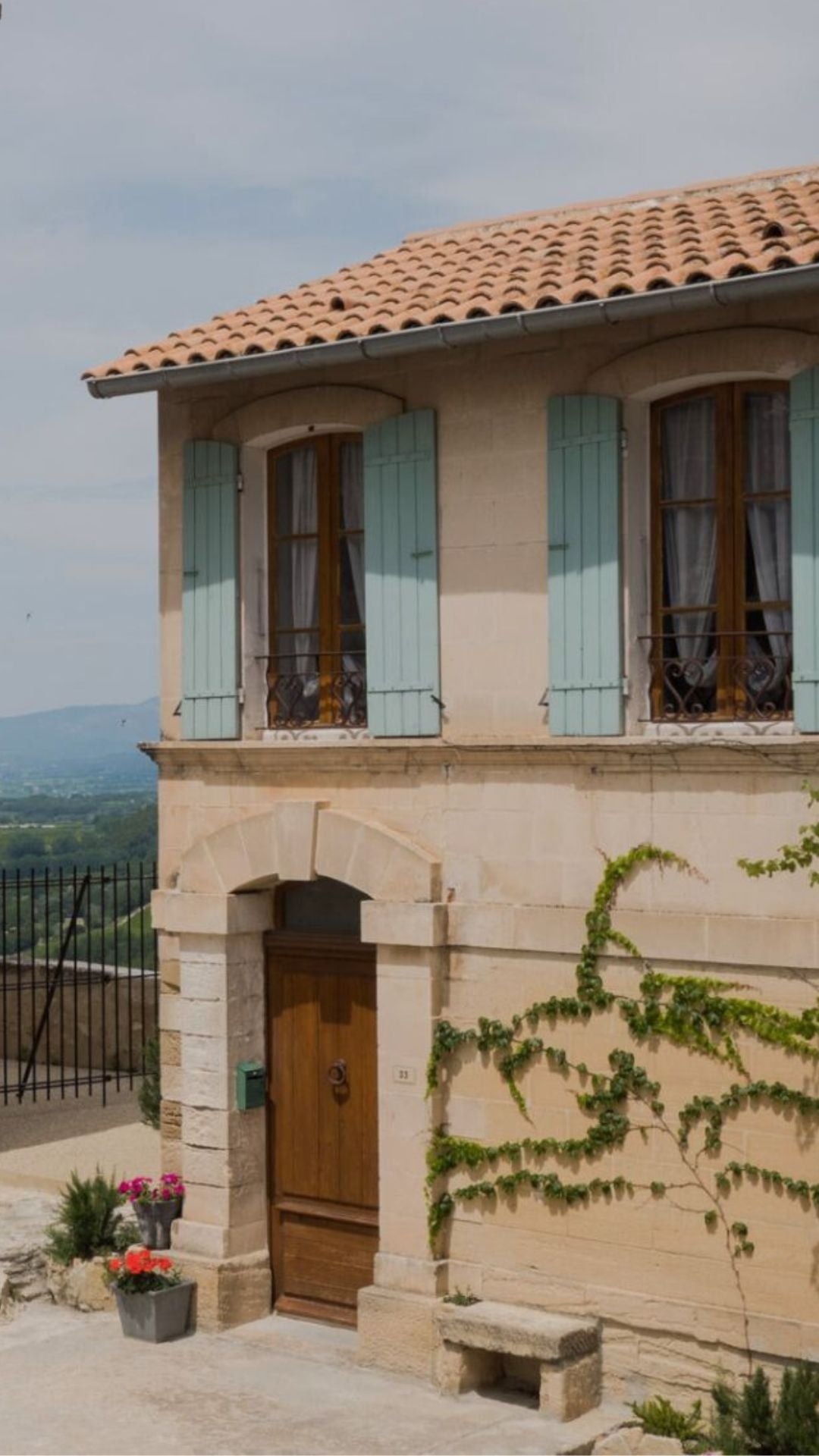 Hilltop house in Venasque. Shuttered windows, cobblestone streets, soft pastel tones and climbing plants.