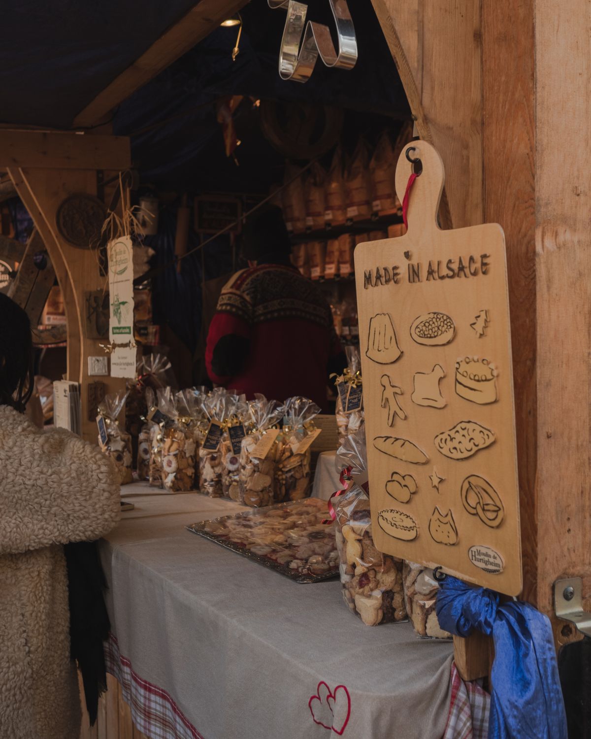 Christmas market wood stand with plastic wrapped candies and cookies.