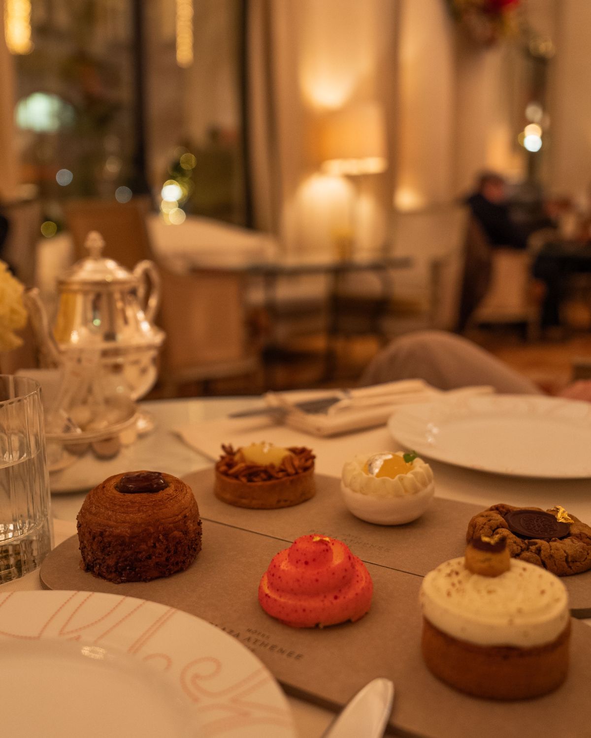 Small sweets, on a table with white dishes in a coffee setting.