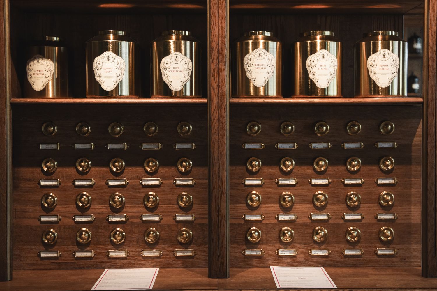 A wooden shelf, with golden brass pots and buttons on the back.