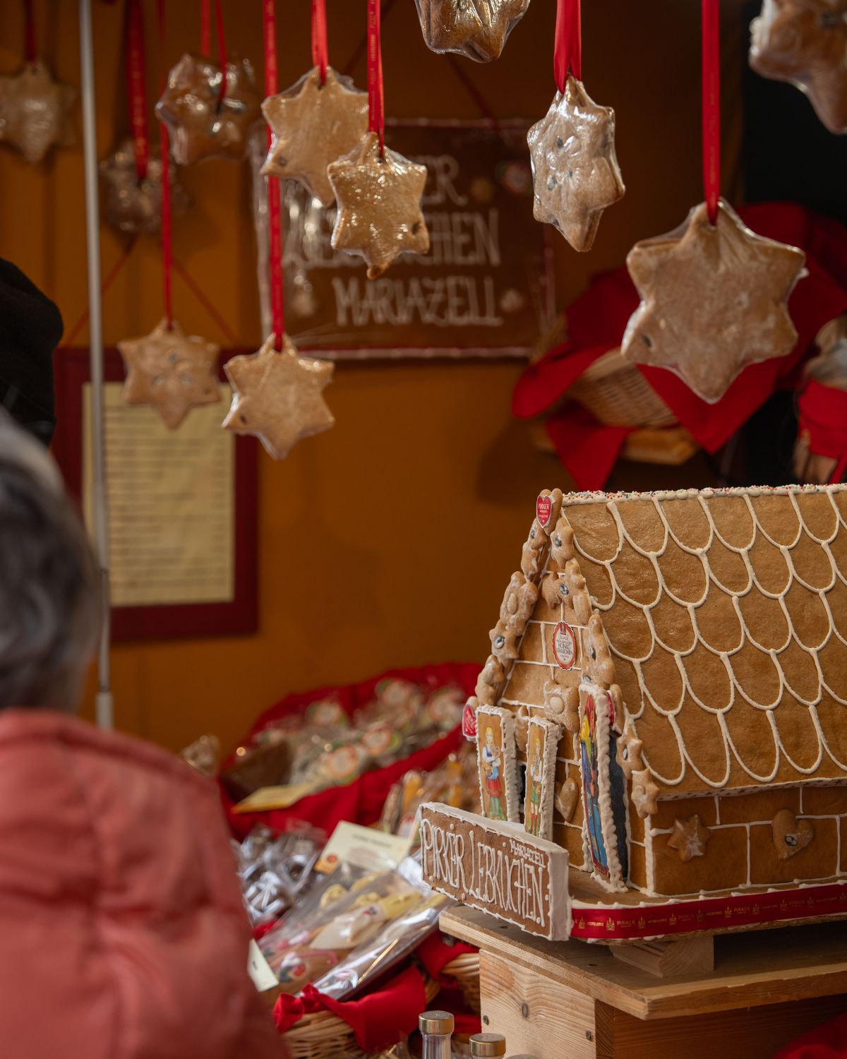 A Christmas market stand, with a gingerbread house and other sweets.