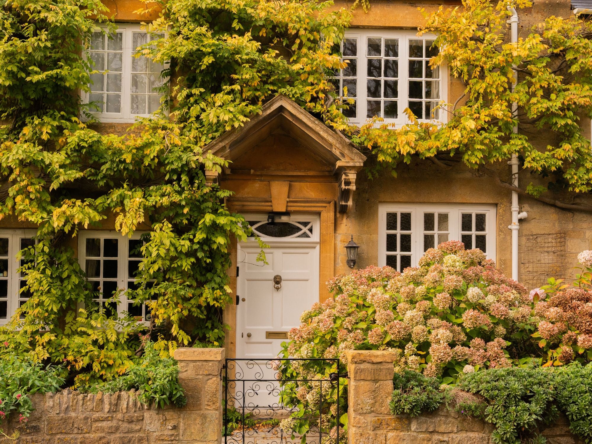 Victorian-style house, near Broadway, in the Cotswolds, with greenery and flowers in front