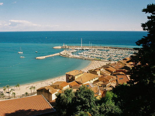 The rooftops of Menton, its harbour and the Plage des Sablettes, with the azure Mediterranean bathing it on a sunny Summer day