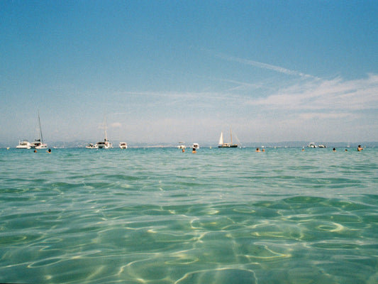 The crystal-clear waters of Porquerolles with the people swimming and the yachts anchored at bay