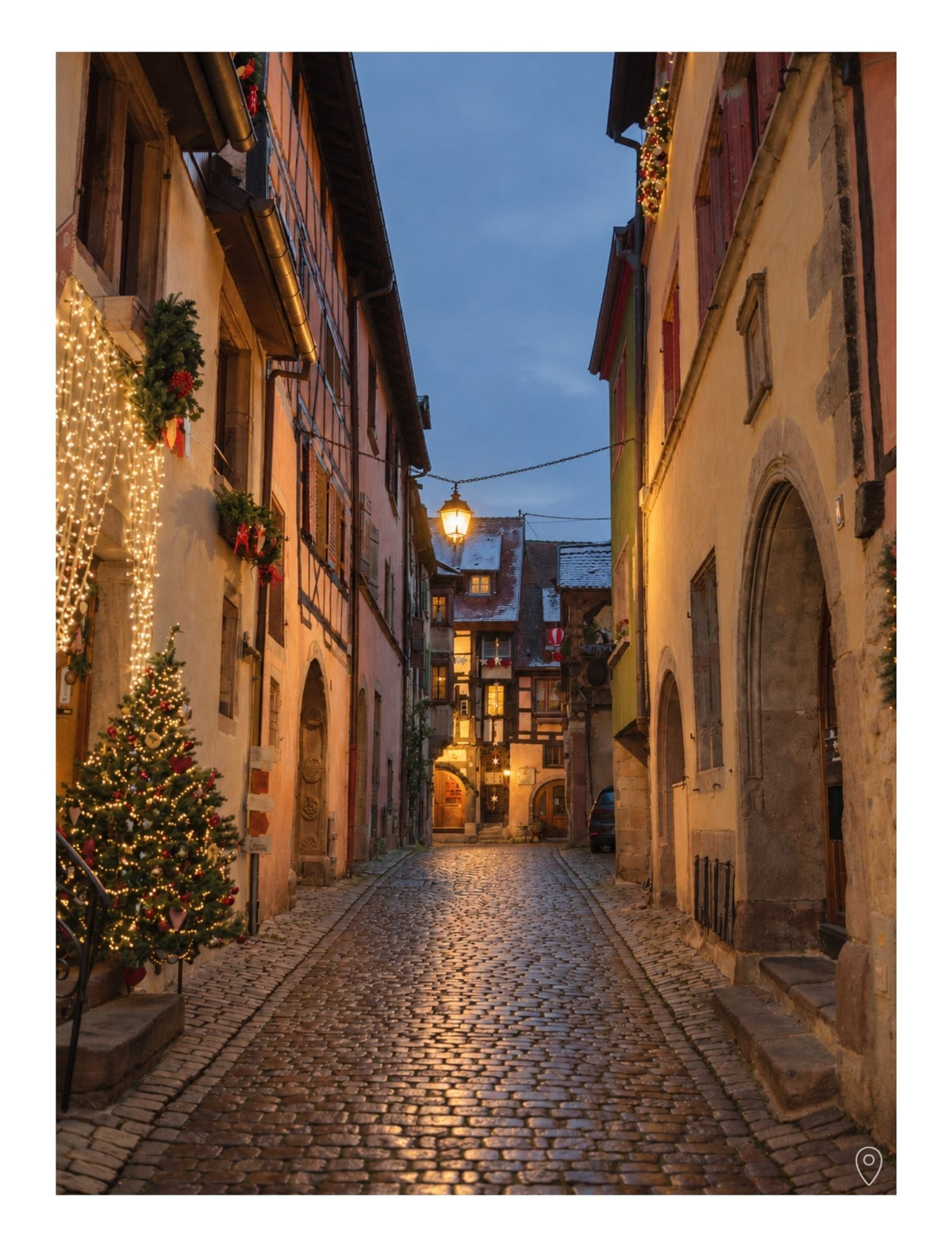 A page inside the Guide to Alsace at Christmas, by Simply Slow Traveler, showcasing an illuminated cobbled street lined with Alsatian houses at dusk