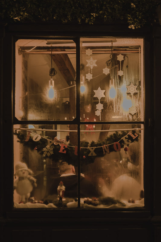 An illuminated window from a restaurant at evening time decorated with Christmas elements in Strasbourg, Alsace