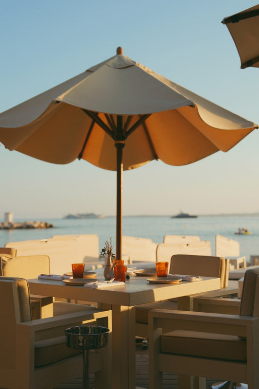 A table set for dinner with a parasol at sunset in the restaurant Baba in Cap d'Antibes, French Riviera