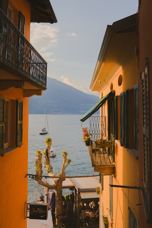 Glimpses of Lake Como in the late afternoon in between the pastel coloured houses of Varenna