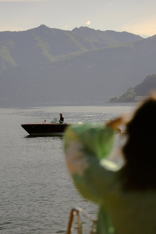 Watching as a wooden riva boat goes by in Lago di Como