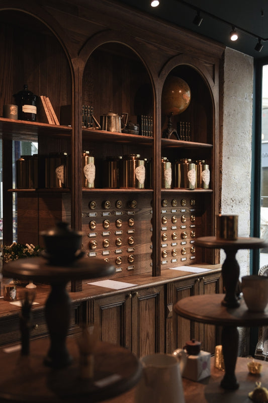 The interior of the tea store Conservatoire des Hémisphères, with wooden shelves and tin cans of tea, in Paris