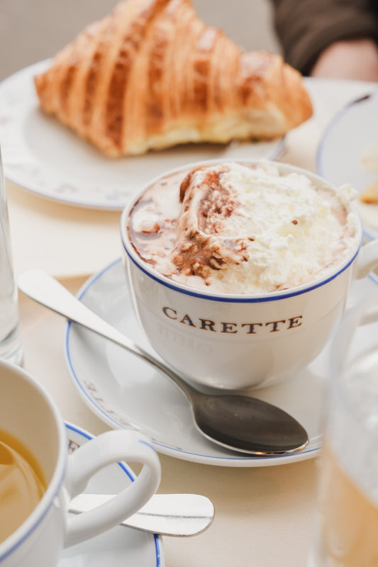 A hot chocolate with whipped cream and a croissant at Café Carette, in Paris