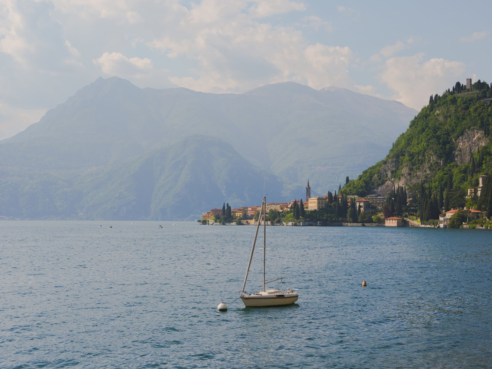 Views of Varenna in the distance, with its unmistakable Villas, and a sailing boat at the bay