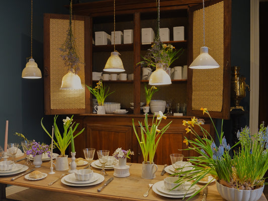 A table set with ceramic items and flowers in shop of Alix D Reynis, in Paris