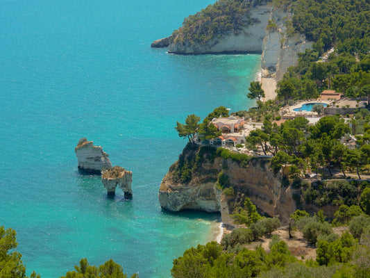 The Faraglioni off Baia dei Mergoli surrounded by turquoise waters, in the Gargano Peninsula in Puglia, Italy