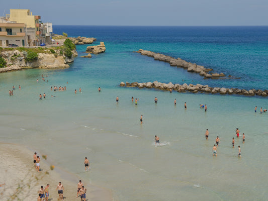 The clear waters of the beach of Otranto, in Puglia, Italy, with the kids playing in the water