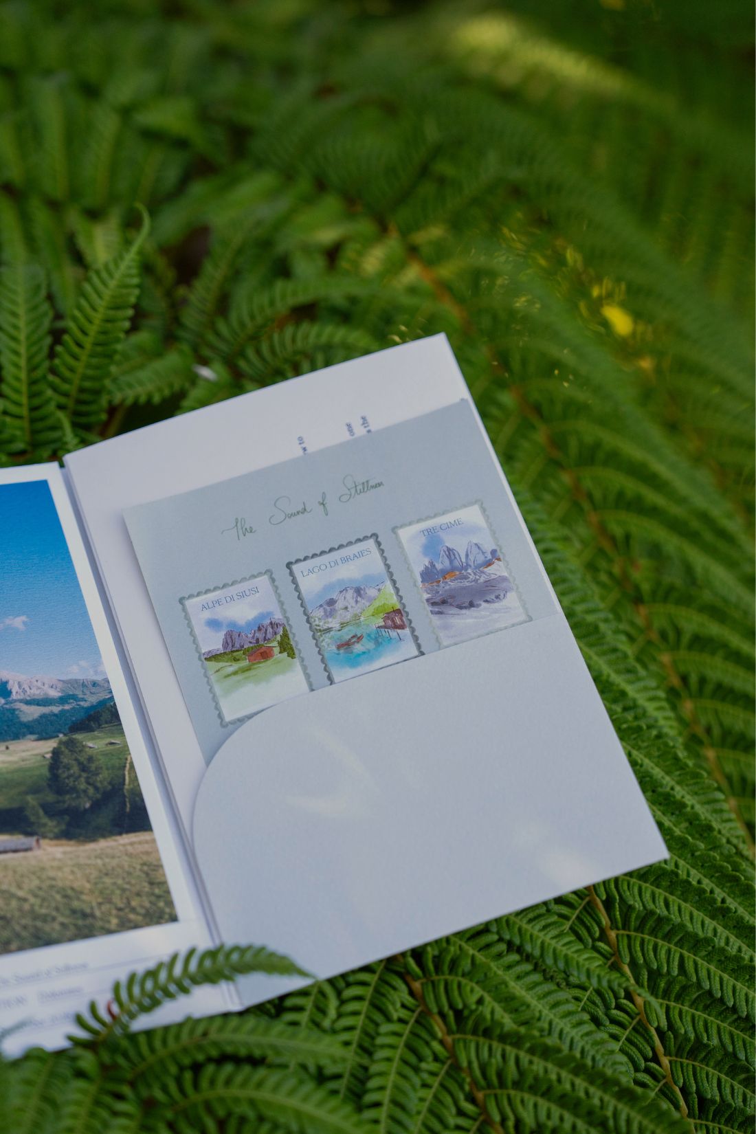 The open fold-out from the September 2026 'Dolomites' edition of Simply Slow Mail, by Simply Slow Traveler, where the illustration on the interior of the fold-out, as well as one of the postcards and the sticker sheet can be seen