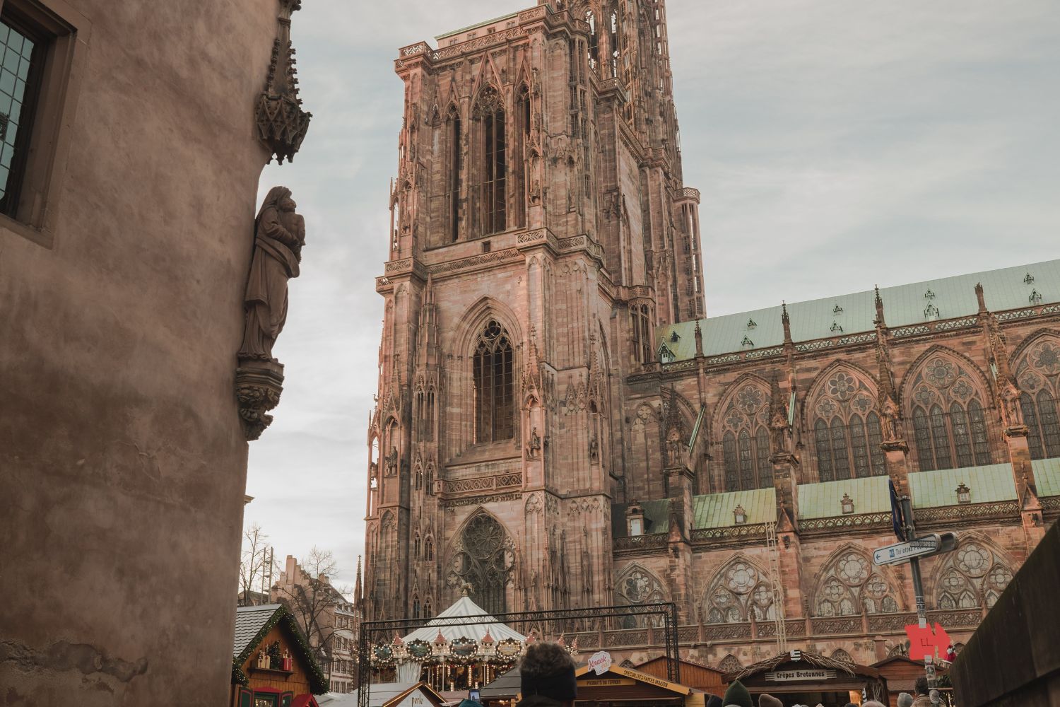 Strasbourg's Cathedral at daylight with a Christmas market surrounding it.