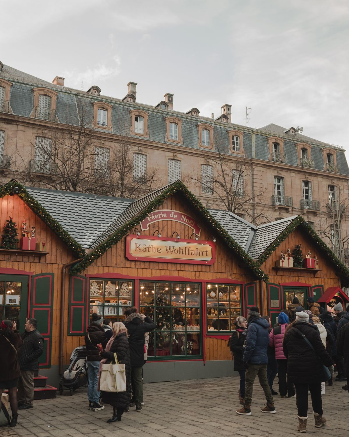 Christmas market wooded stands with the Cathedral of Strasbourg behind it.