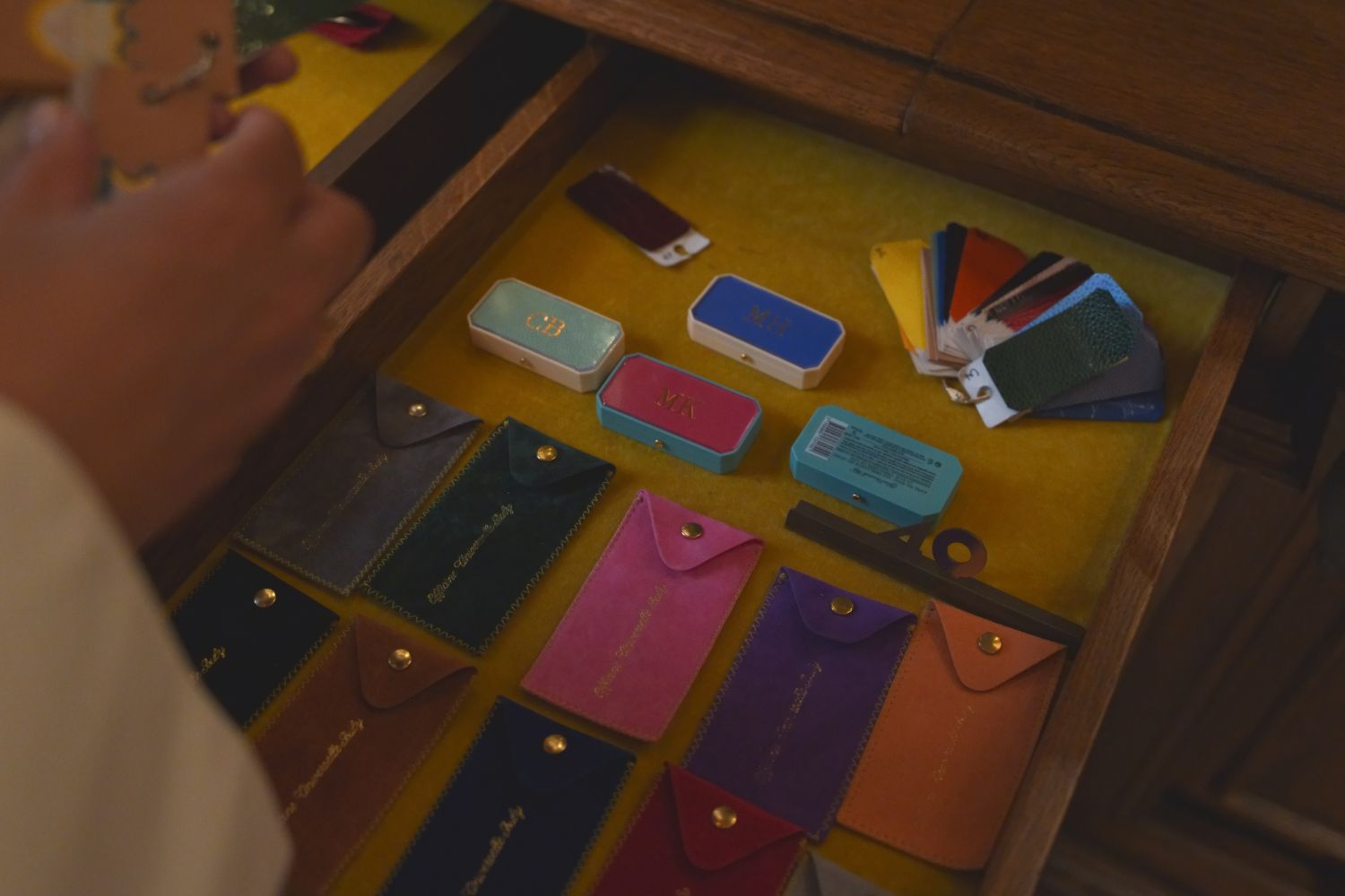 Little leather bags and cases, inside a yellow velvet wooden drawer.