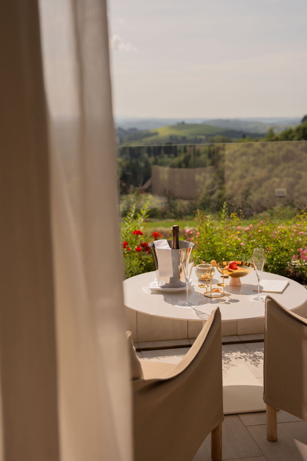 Balcony with outdoor contemporary light furniture, facing the green hills of Tuscany. 