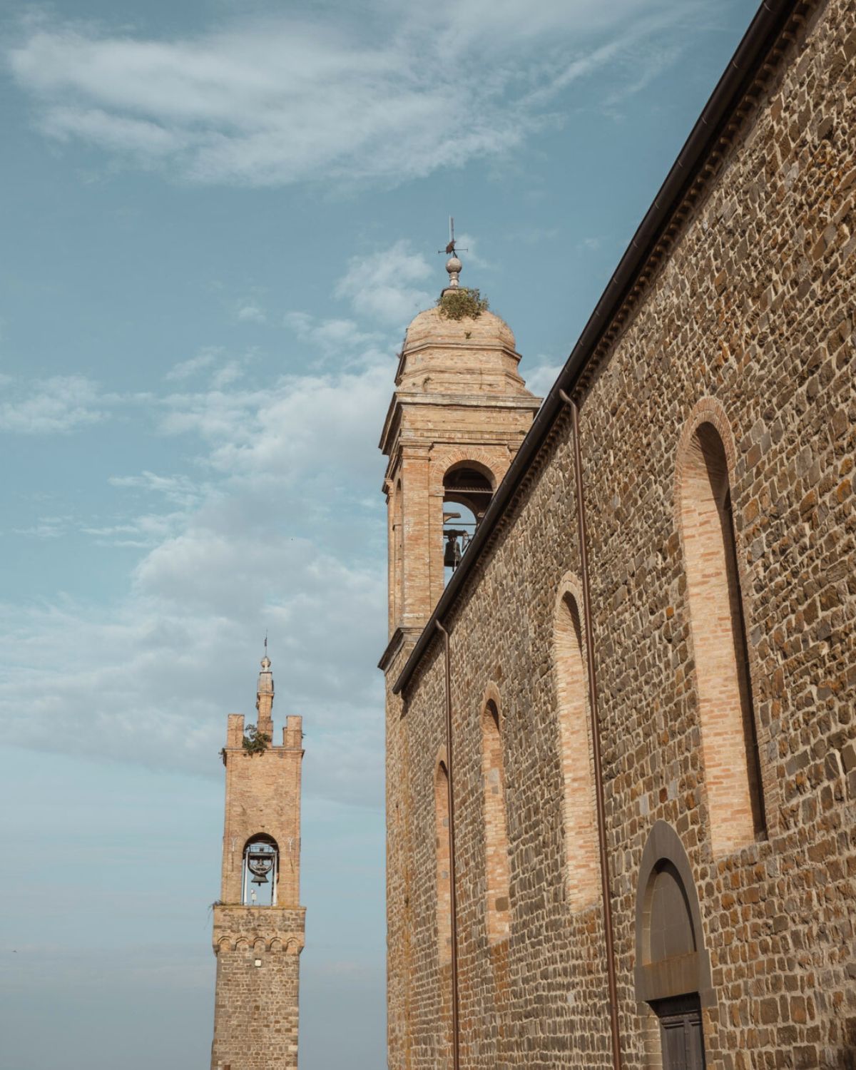Church bells standing on two cobbled stone towers.