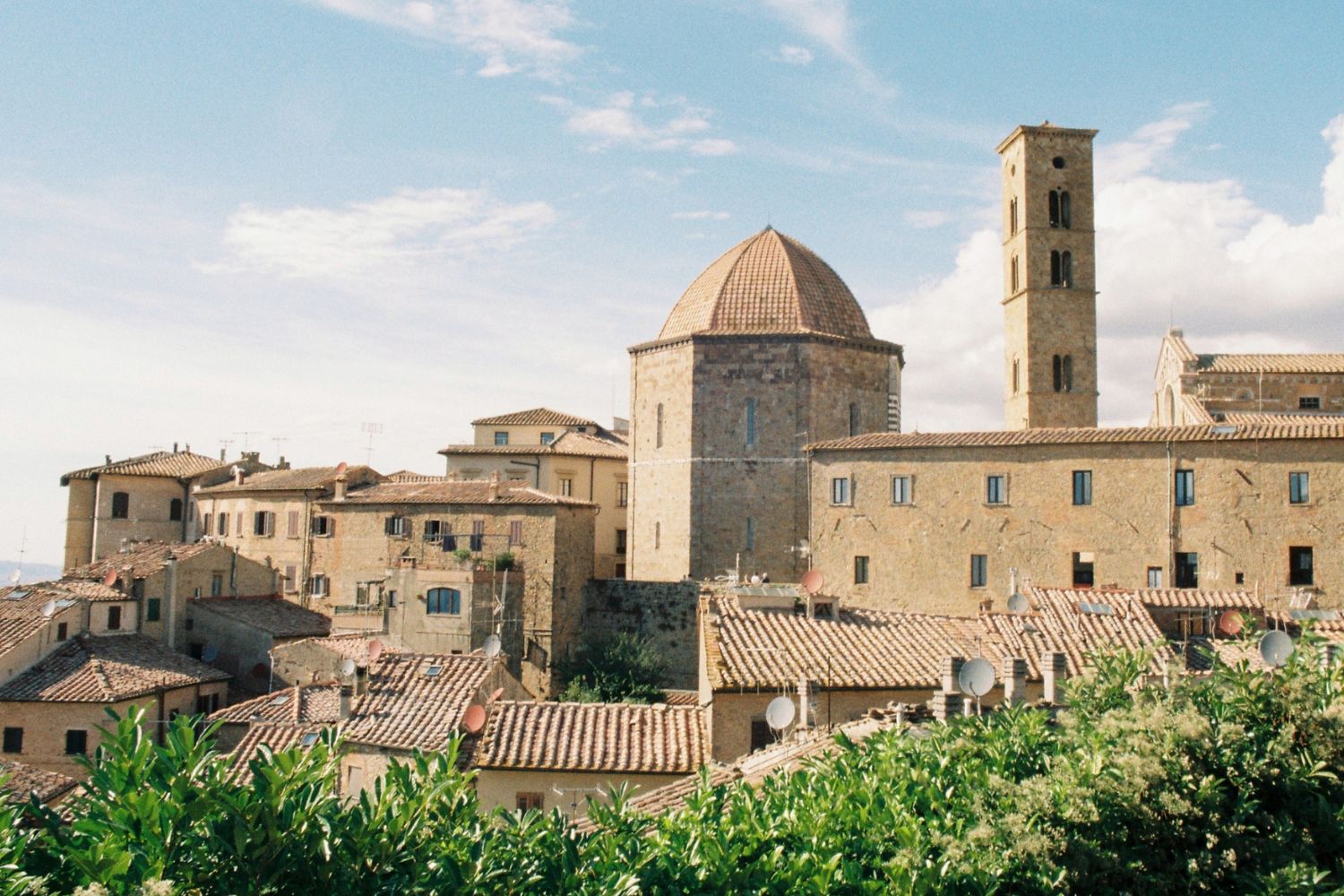 Yellow toned village with cobble stoned buildings and a tower.
