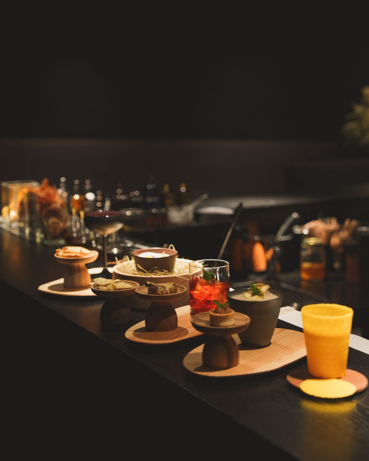 Petit fours of several kinds on top of a dark wood bar balcony.