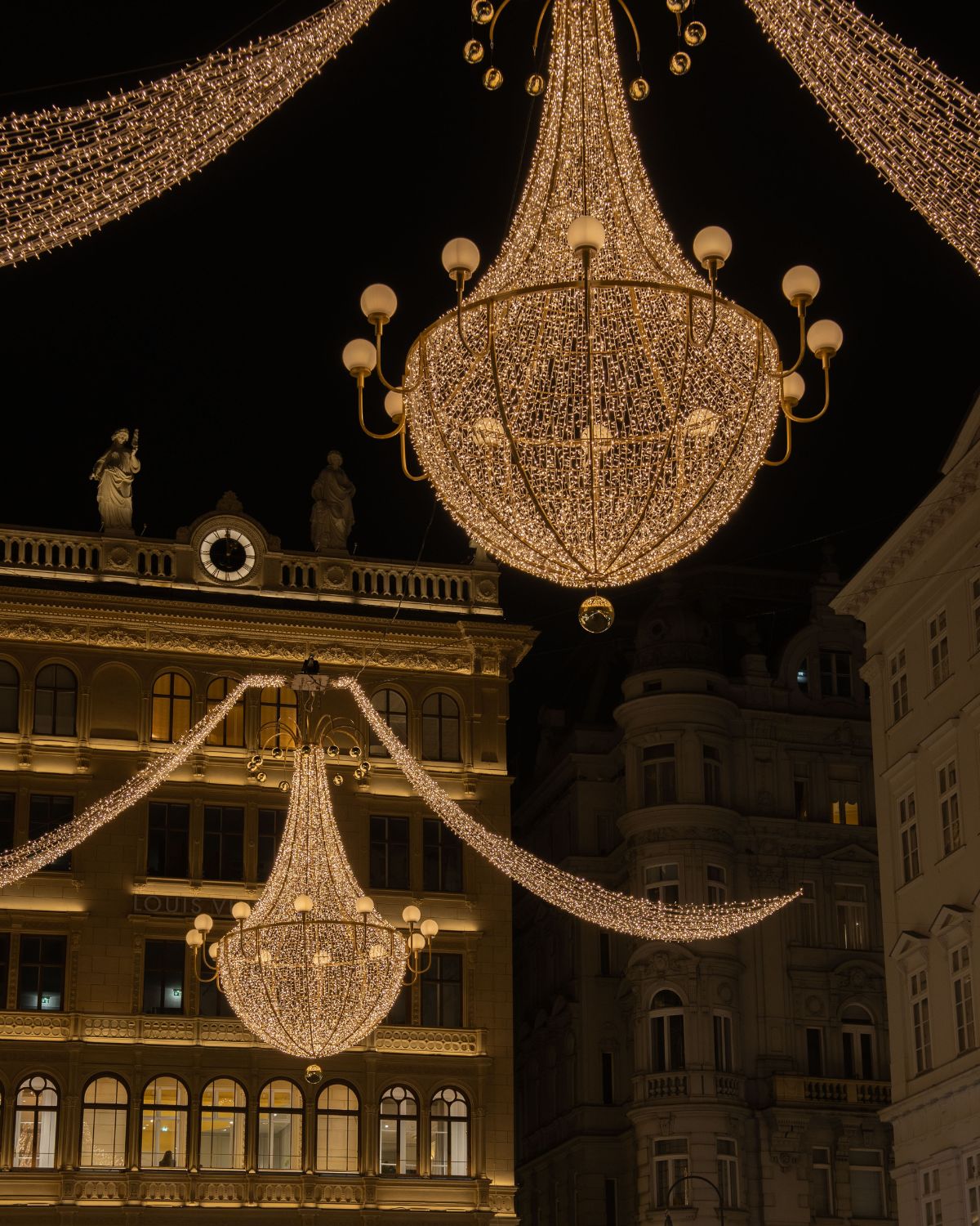 Classic building façades lit up with Christmas lights and adornments.